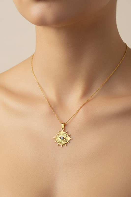 womans neckline wearing a Gold necklace with a sun-shaped pendant featuring an eye design on a white background