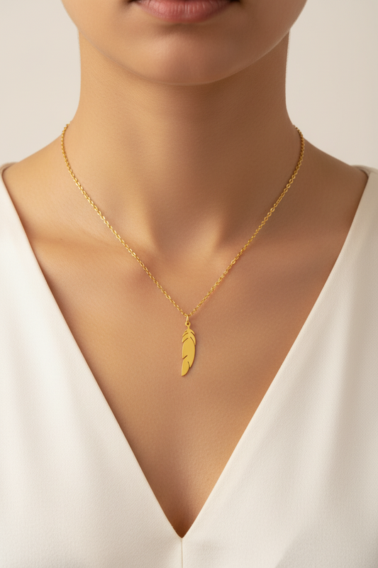 womans neckline waering the Gold angel feather necklace with a white v neck tshirt on a white background