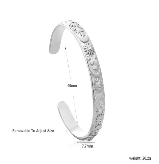 Silver celestial bracelet with engraved design on a white background