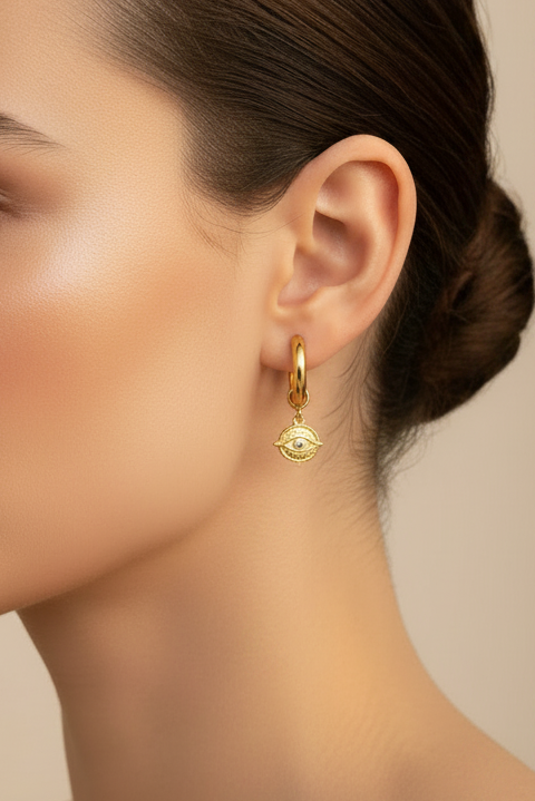 Gold hoop huggie earrings with four directions charms on womans side profile